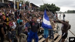 Cientos de migrantes hondureños se reúnen a la orilla del río Suchiate en la frontera entre Guatemala y México, en Tecún Umán, Guatemala, el jueves 18 de octubre de 2018. 
