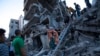 Los palestinos inspeccionan los daños del edificio destruido después de los ataques aéreos israelíes en la Franja de Gaza, el 10 de octubre de 2023. 
