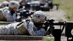 FILE - In this Sept. 18, 2012 file photo, female soldiers from 1st Brigade Combat Team, 101st Airborne Division train on a firing range while testing new body armor in Fort Campbell, Ky., in preparation for their deployment to Afghanistan. Women may be able to begin training as Army Rangers in 2015 under a plan by the Defense Department. (AP Photo/Mark Humphrey, File)