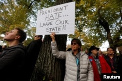 A participant in the march in memory of the victims of the Tree of Life Synagogue shooting, holds a sign opposing U.S. President Donald Trump, in Pittsburgh, Pennsylvania, U.S., October 30, 2018. REUTERS/Cathal McNaughton