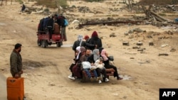 Луѓето се возат во задниот дел на трицикл кој ги превезува од Нусејрат до градот Газа на 10 февруари 2025 година додека раселените луѓе се враќаат дома поради актуелниот договор за прекин на огнот во војната меѓу Израел и Хамас.