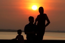 រូបឯកសារ៖ គ្រួសារមួយបាននាំគ្នាមើលថ្ងៃលិច នៅក្បែរច្រាំងទន្លេសាប មុខព្រះបរមរាជវាំង ក្នុងរាជធានីភ្នំពេញ កាលពីថ្ងៃទី ២៤ ខែមករា ឆ្នាំ២០២០។