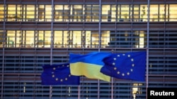 Brussels မြို့တော် ဥရောပကော်မရှင်ရုံးချုပ်မှာ လွှင့်ထားတဲ့ EU ဥရောပသမဂ္ဂအလံနဲ့ ယူကရိန်းအလံများ (REUTERS/Yves Herman)