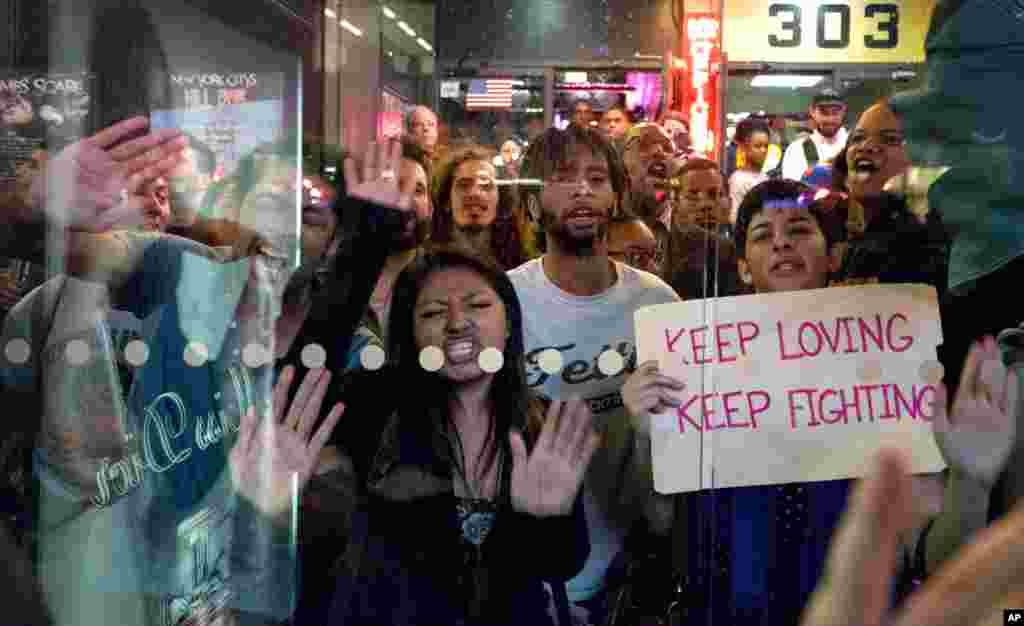Protesters slam their hands against a bus shelter as they chant, in New York, April 29, 2015.