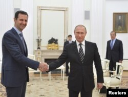 Russian President Vladimir Putin, right, shakes hands with Syrian President Bashar al-Assad during a meeting at the Kremlin in Moscow, Russia, Oct. 20, 2015.