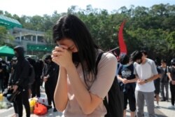Protesters pause for a moment of silence after disrupting a graduation ceremony at the University of Science and Technology and turning the stage into a memorial venue for Chow Tsz-Lok in Hong Kong, Nov. 8, 2019.
