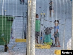 FILE - An undated photo by Amnesty International purports to show children playing near a fence at an Australian-run detention center on the Pacific island of Nauru.