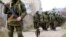 Armed men, believed to be Russian servicemen, walk outside a Ukrainian military base in Perevalnoye, near the Crimean city of Simferopol, March 14, 2014.