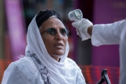 FILE - Ethiopians have their temperature checked for symptoms of the new coronavirus, at the Zewditu Memorial Hospital in the capital Addis Ababa, Ethiopia, March 18, 2020.