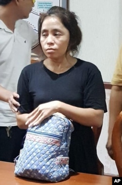 Sam Sokha, who threw a shoe at a billboard depicting Cambodian Prime Minister Hun Sen, stands in police station in Phnom Penh, Cambodia, Feb. 8, 2017.