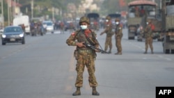 A Myanmar soldier stands guard on a road amid demonstrations against the military coup in Naypyidaw on February 17, 2021. (Photo by STR / AFP)