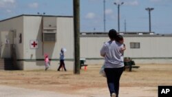 In this Aug. 23, 2019 file photo, immigrants seeking asylum walk at the ICE South Texas Family Residential Center, in Dilley, Texas. (AP Photo/Eric Gay, File) 