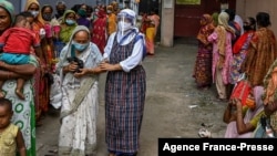 Nuns from Missionaries of Charity distribute food to the needy on the occasion of 'Peace Day' to mark the death anniversary of Mother Teresa at the Mother House in Kolkata, Sept. 5, 2021.