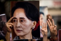 FILE - A protester holds a photo of detained Myanmar civilian leader Aung San Suu Kyi during a demonstration against the military coup outside the Myanmar Embassy in Bangkok on Feb. 7, 2021.