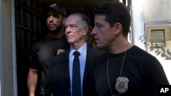 Carlos Nuzman, President of the Brazilian Olympic Committee, center, is escorted by federal police officers after being taken into custody at his home, in Rio de Janeiro, Brazil, Oct. 5, 2017.