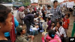 រូបឯកសារ៖ ពលករ​ចំណាកស្រុក​ខ្មែរ​ដែល​ត្រឡប់​ពី​ប្រទេស​ថៃ​វិញ​នាំគ្នា​ហូប​អាហារ​ពេលព្រឹក​ ខណៈ​ពេល​ដែល​ពួកគេ​រង់ចាំ​ជិះ​រថយន្ដឈ្នួល​ទៅ​កាន់​ស្រុក​កំណើត​របស់​ពួកគេវិញ​នៅ​ខេត្ត​កំពង់ស្ពឺ ក្នុង​ដំណើរ​ចេញ​ពី​ច្រក​ព្រំដែន​អន្តរជាតិ​ខ្មែរ​ថៃ នៅ​ប៉ោយប៉ែត ថ្ងៃ​ទី​១៨ ខែមិថុនា ឆ្នាំ​២០១៤។