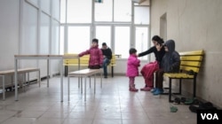 A family wait their turn to make a legal crossing at one of the official camps by the Serbia/Hungary border. Hungary now only allows 10 refugees and migrants to cross a day. (VOA /J. Owens)