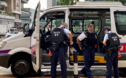 两名香港国安法被告李宇轩及陈梓华8月19日出庭认罪，大批穿着防弹背心的警员在高等法院外戒备 (美国之音/汤惠芸)