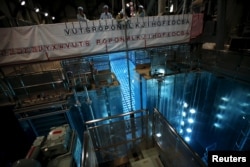 Employees of Kyushu Electric Power Co. hoist a fuel rod using a crane from a spent fuel pool at Sendai nuclear power station, in Satsumasendai, Kagoshima prefecture, Japan, July 8, 2015. REUTERS/Issei Kato