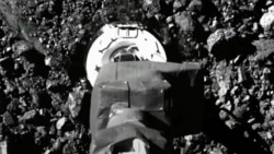 In this image taken from video released by NASA, the Osiris-Rex spacecraft touches the surface of asteroid Bennu on Tuesday, Oct. 20, 2020. (NASA via AP)