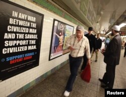 Seorang anggota Dewan Hubungan Amerika-Islam (CAIR) berbicara dengan para pelaju di depan sebuah poster iklan bertuliskan "Dukung Israel/Kalahkan Jihad" di stasiun kereta subway Times Square, New York, 24 September 2012. (Foto: Brendan Mcdermid/Reuters/arsip)