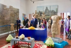 មន្ត្រី​តំណាង​ស្ថានទូត​សហរដ្ឋអាមេរិក​និង​មន្ត្រី​តំណាង​ក្រសួង​វប្បធម៌​និង​វិចិត្រ​សិល្បៈ​ចូលរួម​ក្នុង​ពិធី​ប្រគល់​រូបបដិមា​ខ្មែរ​ចំនួន​ពីរ ​ដែល​ស្ថានទូត​សហរដ្ឋអាមេរិក​ប្រគល់​ជូន​កម្ពុជា​វិញ ក្រោយ​ពី​រឹបអូស​បាន​កាល​ពី​ឆ្នាំ​២០០៥​និង​២០១៧​នៅ​សហរដ្ឋអាមេរិក ថ្ងៃ​ទី​៣ ខែមេសា ឆ្នាំ​២០២០។ (រូបថត​ផ្ដល់​ឲ្យ​ដោយ​ស្ថានទូត​អាមេរិក)