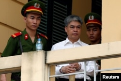 Former PetroVietnam chairman Nguyen Xuan Son is escorted by police as he leaves court after the verdict session in Hanoi, Vietnam, Sept. 29, 2017.