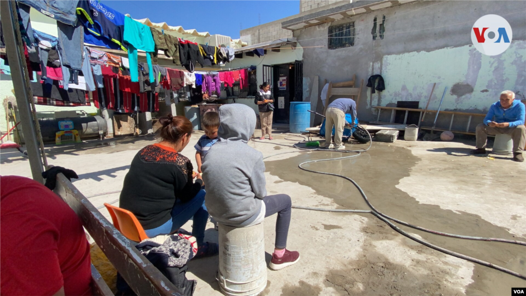 Inmigrantes aguardan sentados en el patio del refugio El Buen Samaritano, en Ciudad Juárez, México, su hogar durante la larga espera, en ocasiones, ya de años.