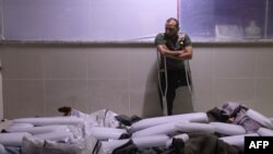 Sirijski amputirac gleda u tela civila koji su prema izveštajim ubijeni u režimskom vazdušnom udaru na grad Muhambal, u severnoj pokrajini Idlib, u kom je ubijeno 14 civila uključujući sedmoro dece.