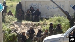 This image posted on the Twitter page of Syria's al-Qaida-linked Nusra Front, April 25, 2015, shows Nusra Front fighters in the town of Jisr al-Shughour, Idlib province, Syria.