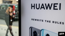 FILE - A pedestrian walks past a Huawei product stand at an EE telecommunications shop in central London, Britain, April 29, 2019.