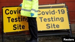 FILE - A member of NHS Test and Trace staff sets up a mobile testing center amid the outbreak of the coronavirus disease in the Moston area of Manchester, Britain, Feb. 17, 2021. 