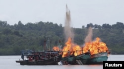 FILE - Malaysian and Vietnamese fishing boats are destroyed for illegal fishing by the Ministry of Maritime Affairs and Fisheries, police and navy, in Batam, Riau Islands, Indonesia, April 5, 2016. The Indonesian government reportedly sank 28 illegal foreign fishing boats simultaneously in nine locations across the country. 