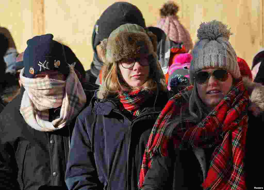 Parade-goers try to keep warm during the Macy's Thanksgiving Day Parade in Manhattan,New York, Nov. 22, 2018. New York City has issued an extreme cold weather alert and is urging anyone going outside to wear hats, scarves, gloves and layered clothing and to keep their fingertips, earlobes, and noses covered to prevent frostbite.
