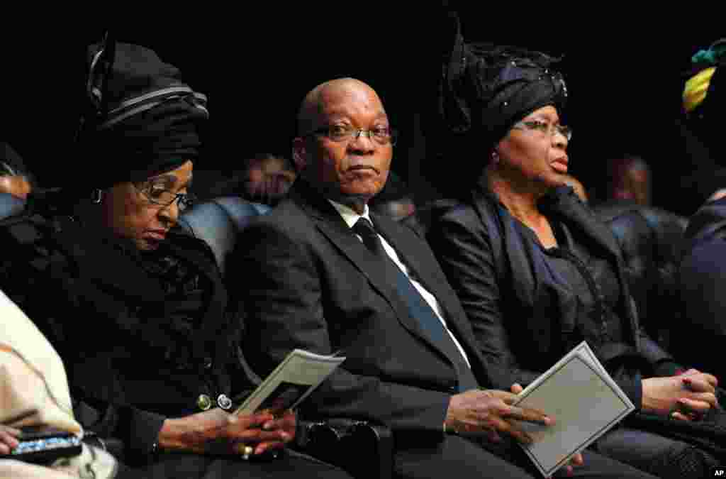 South African President Jacob Zuma sits between Winnie Madikizela-Mandela, Nelson Mandela's former wife, and Nelson Mandela&rsquo;s widow Graca Machel, right, attend the funeral service for former president in Qunu.