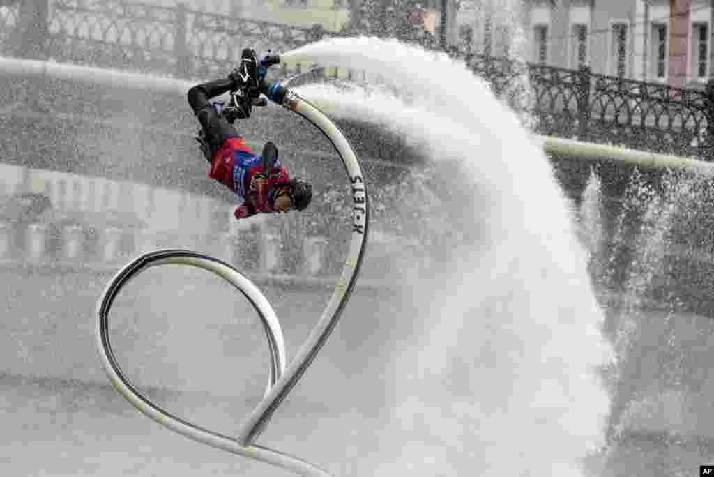 Andrei Smirnov performs on a hydro pipe on the Moscow River Channel during a SUP (Stand Up Paddle)-Surfing festival in Moscow, Russia, Sept. 19, 2020.