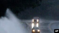 Varios automóviles avanzan por un camino con muchos charcos en Helena, Alabama, el viernes 25 de octubre. AP.