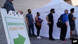 People wait in line for COVID-19 vaccinations at an event at La Bonita market, a Hispanic grocery store, July 7, 2021, in Las Vegas, as the areas with the lowest vaccination rates have the highest rates of new cases. 
