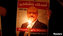Un manifestante sostiene un cartel con una foto del periodista saudita Jamal Khashoggi en el exterior del consulado de Arabia Saudita en Estambul.