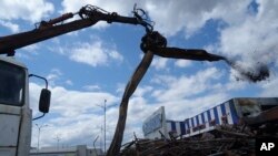 Екскаватор розчищає завали торгового комплексу «Епіцентр» у Харкові, Україна, четвер, 6 червня 2024 р. У травні російські військові під час бомбардування «Епіцентру» плануючими бомбами загинули 19 людей, у тому числі двоє дітей. (AP Photo/Євген Малолєтка)