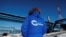 FILE - An employee in jacket reading "Power of Siberia" is seen at the Atamanskaya compressor station facility of Gazprom's "Power of Siberia" gas pipeline outside the far eastern town of Svobodny, in Russia's Amur region, Nov. 29, 2019.