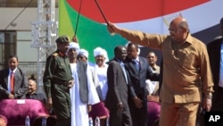 Sudan’s President Omar al-Bashir greets his supporters at a rally in Khartoum, Sudan, Wednesday, Jan. 9, 2019. Al-Bashir told the gathering of several thousands of supporters in the capital that he is ready to step down only “through election.”