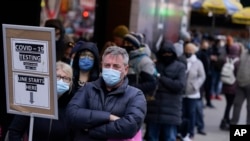 FILE - People wait in line at a COVID-19 testing site in Times Square, New York City, Dec. 13, 2021. Omicron has raced ahead of other variants and is now the dominant version of the coronavirus in the United States.