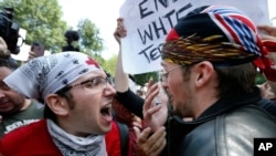 A counterprotester, left, confronts a supporter of President Donald Trump, Aug. 19, 2017, in Boston.