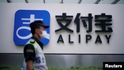 一名保安站在蚂蚁集团支付宝上海办公室的标识前。（2020年9月22日）
