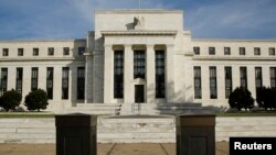 FILE - The U.S. Federal Reserve Board building is shown behind security barriers in Washington.