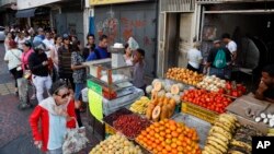 Archivo - Residentes de Caracas esperan en fila para comprar alimentos durante una apagón el 10 de marzo de 2019.