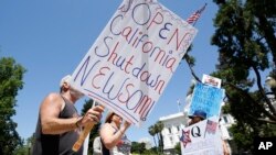 Protesters calling for the end of Gov Gavin Newsom's stay-at-home orders march around the state Capitol in Sacramento, California, May 1, 2020.