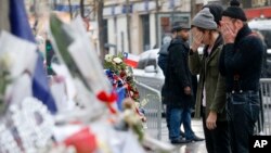 Des membres du groupe Eagles of Death Metal, Jesse Hughes, à droite, et Julian Dorio viennent se recueillir sur l'hommage rendu aux victimes du Bataclan le 8 décembre 2015.