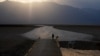 A person walks on a boardwalk at the salt flats at Badwater Basin, Aug. 17, 2020, in Death Valley National Park, Calif. Death Valley recorded a scorching 130 degrees (54.4 degrees Celsius).